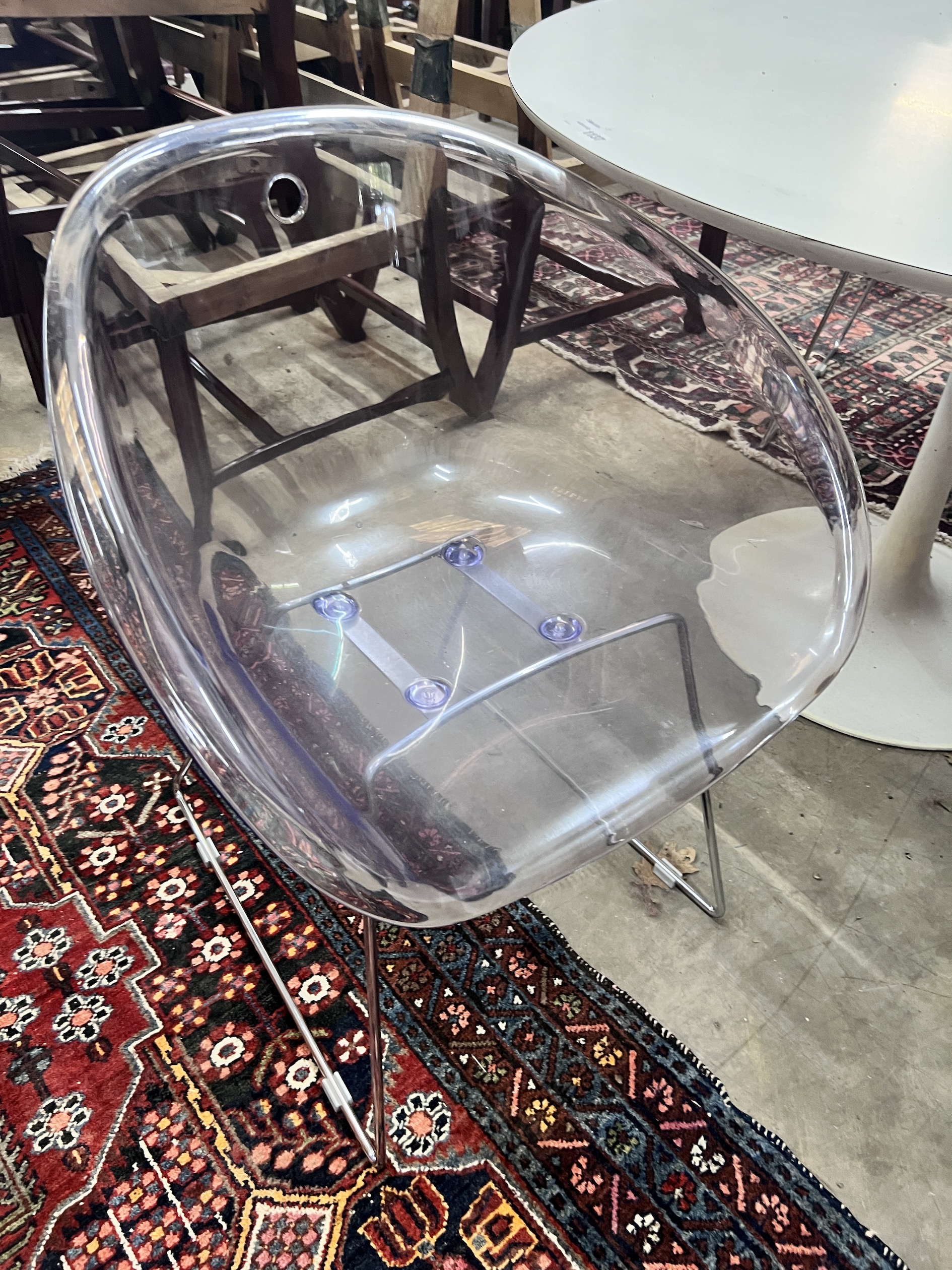 Three Habitat perspex armchairs and a Habitat ‘’Chelsea’’ circular white laminated wood table, diameter 120cm, height 72cm (3)